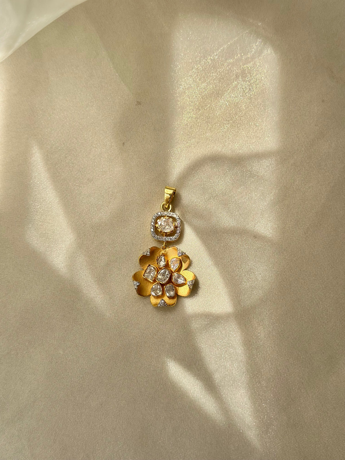 Kusum Polki Pendant featuring sculpted gold-tone flower petals and clustered clear stones beneath a stone-set bail.