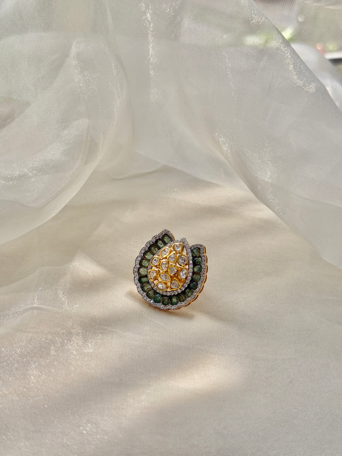 Dua Ring featuring a clear-stone cluster surrounded by a curved dark green border in a gold-tone setting.