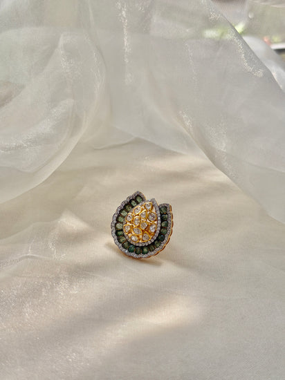 Dua Ring featuring a clear-stone cluster surrounded by a curved dark green border in a gold-tone setting.