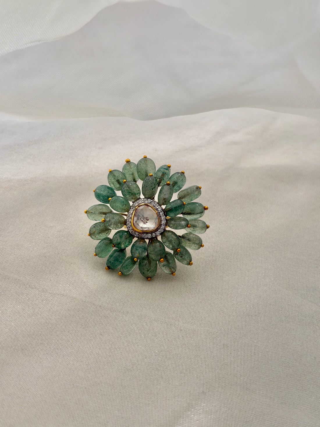 Trisha Ring featuring green oval beads arranged in a floral design around a clear triangular centre.