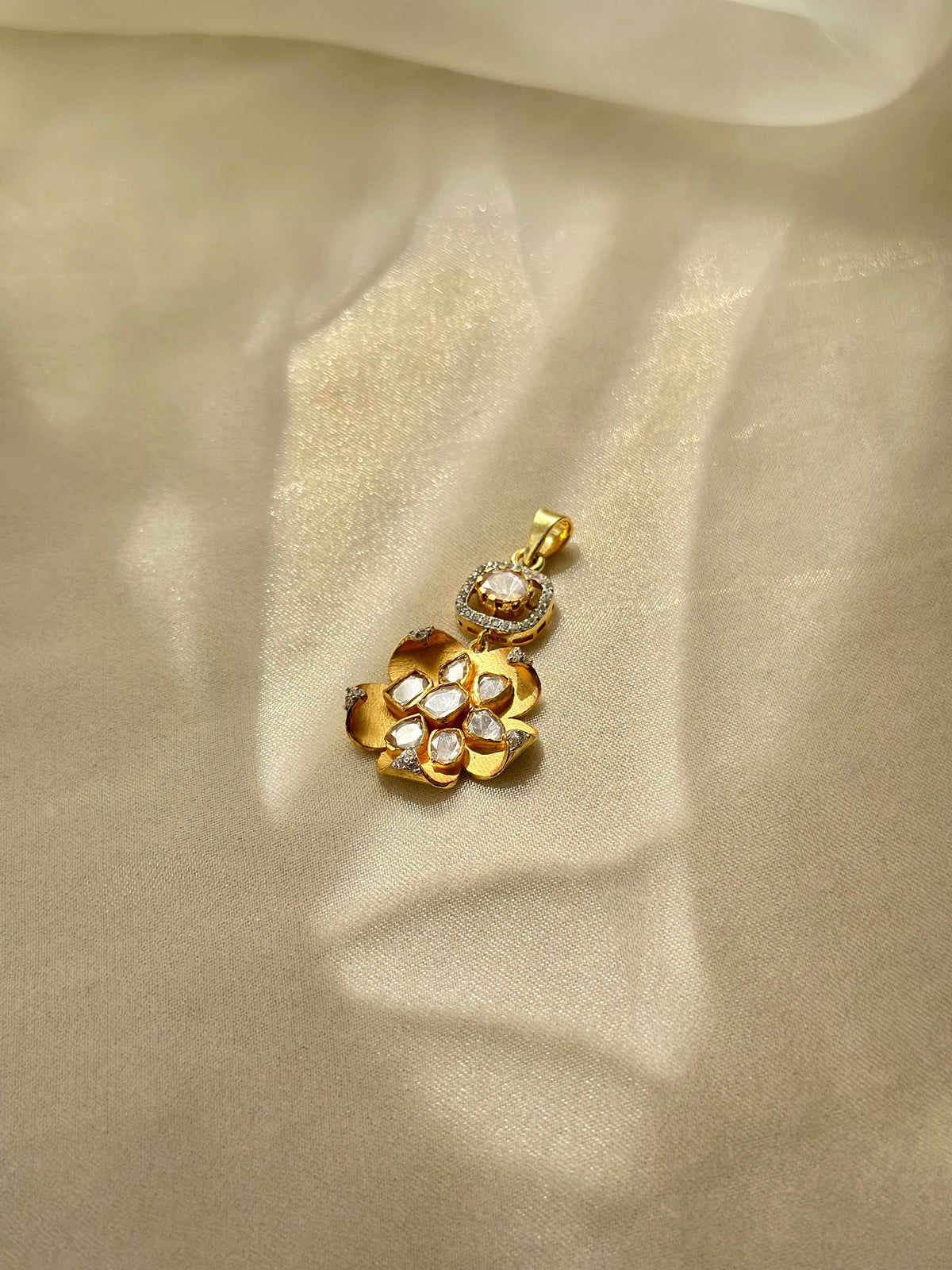 Kusum Polki Pendant featuring sculpted gold-tone flower petals and clustered clear stones beneath a stone-set bail.