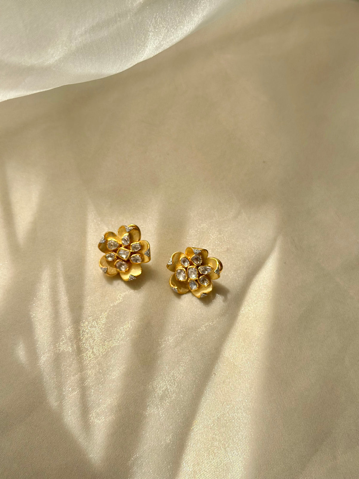Kusum Polki Earrings featuring sculpted gold-tone flower petals with clustered clear-stone centres.