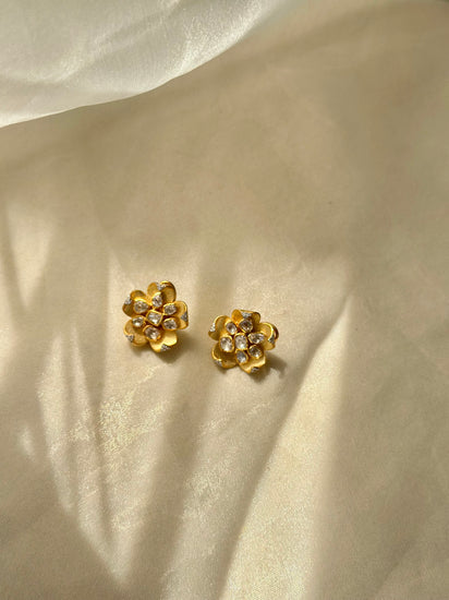 Kusum Polki Earrings featuring sculpted gold-tone flower petals with clustered clear-stone centres.
