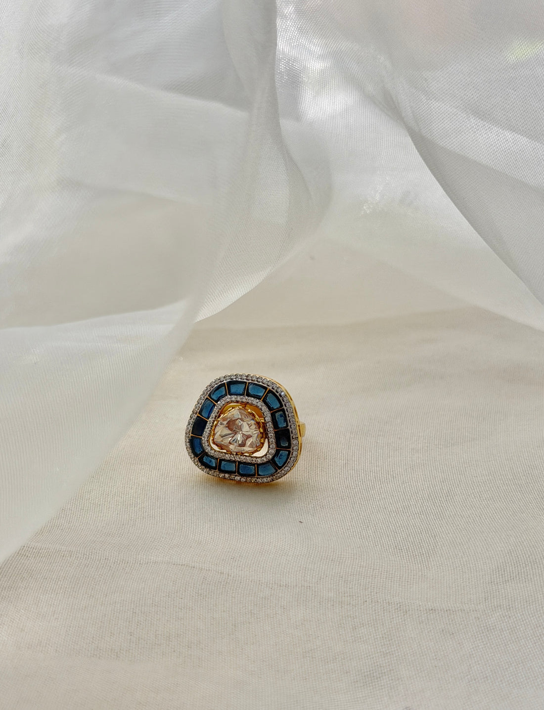 Rukaya Ring featuring a clear triangular centre surrounded by dark blue accents and clear-stone detailing