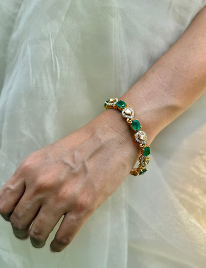Arzaana Bracelet featuring alternating green oval stones and clear teardrop links in gold-tone settings