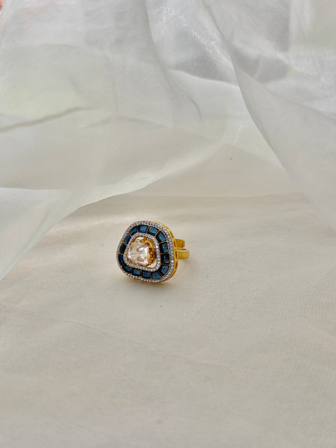 Rukaya Ring featuring a clear triangular centre surrounded by dark blue accents and clear-stone detailing