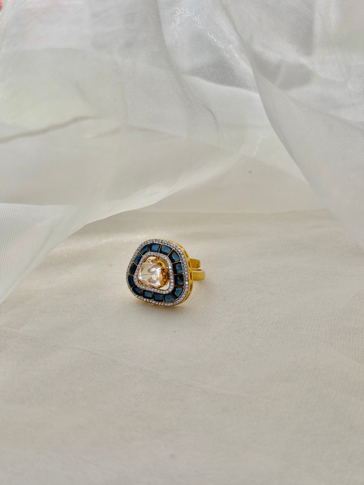 Rukaya Ring featuring a clear triangular centre surrounded by dark blue accents and clear-stone detailing