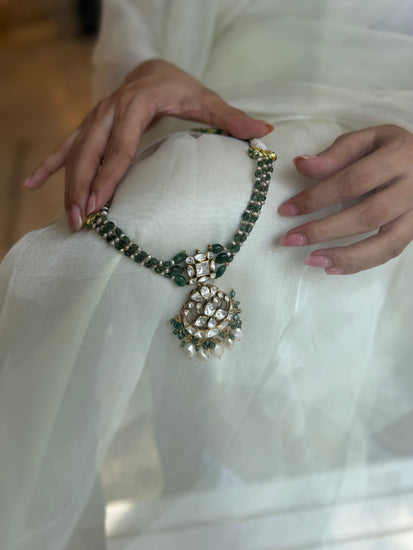 Arohi Necklace featuring green beads, a clear-stone statement pendant and dangling white beads in gold-tone settings.