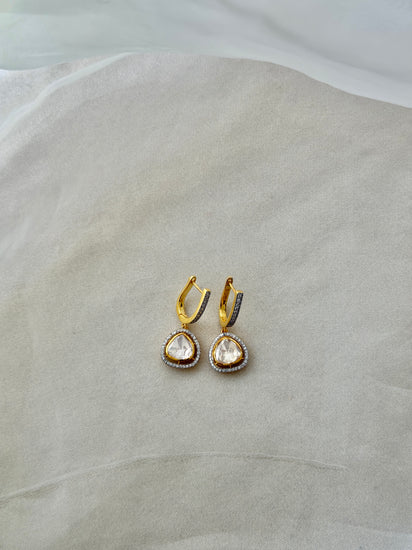 Tilak Earrings featuring clear triangular drops with sparkling stone borders suspended from gold-tone hoops.