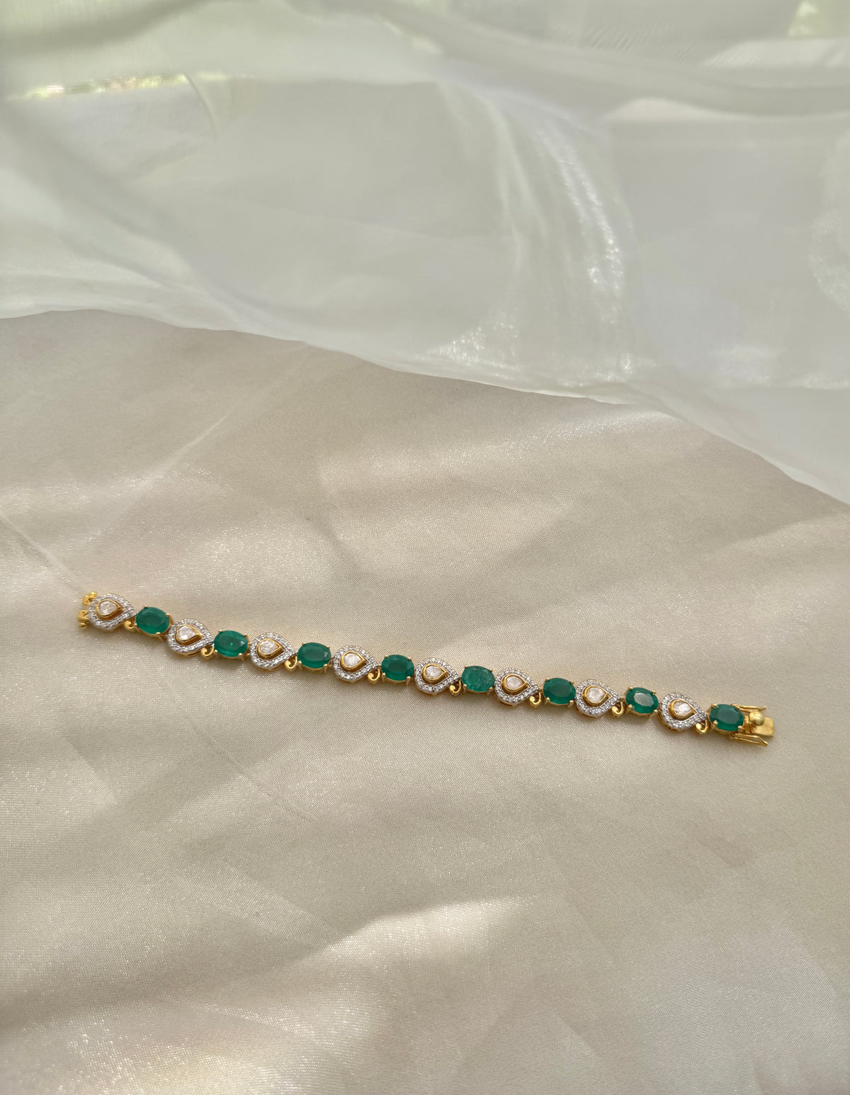 Arzaana Bracelet featuring alternating green oval stones and clear teardrop links in gold-tone settings