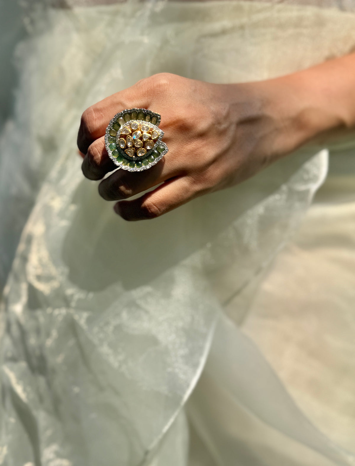 Dua Ring featuring a clear-stone cluster surrounded by a curved dark green border in a gold-tone setting.