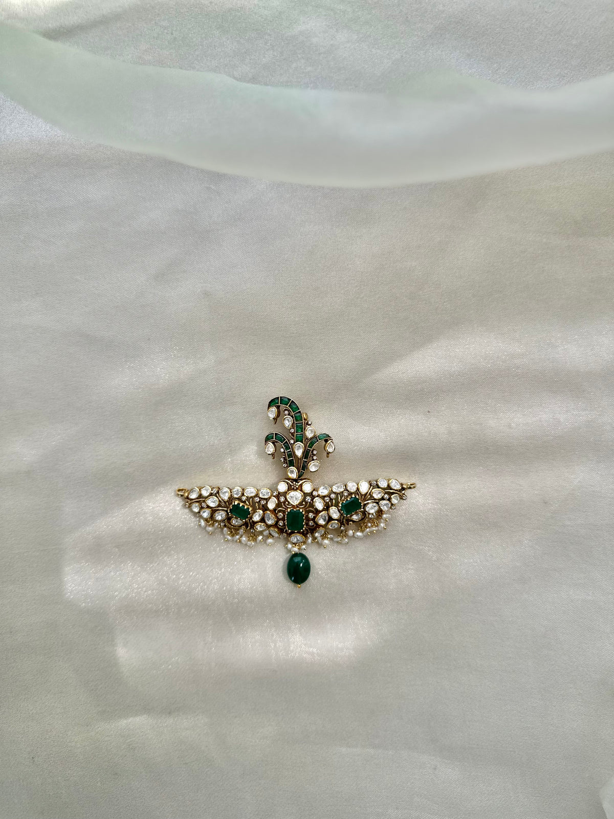 Huzoor Sarpech featuring a curved green plume, clear-stone detailing, white bead fringe and a dangling green bead.