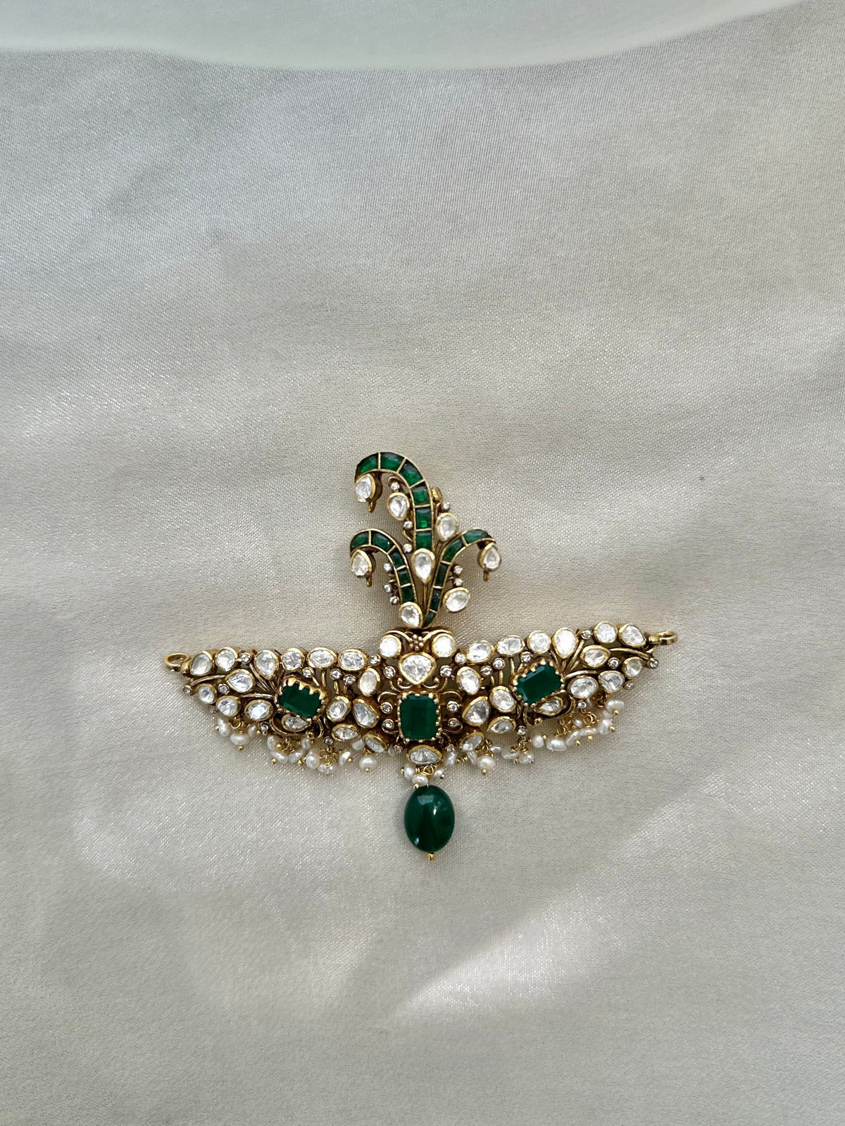 Huzoor Sarpech featuring a curved green plume, clear-stone detailing, white bead fringe and a dangling green bead.