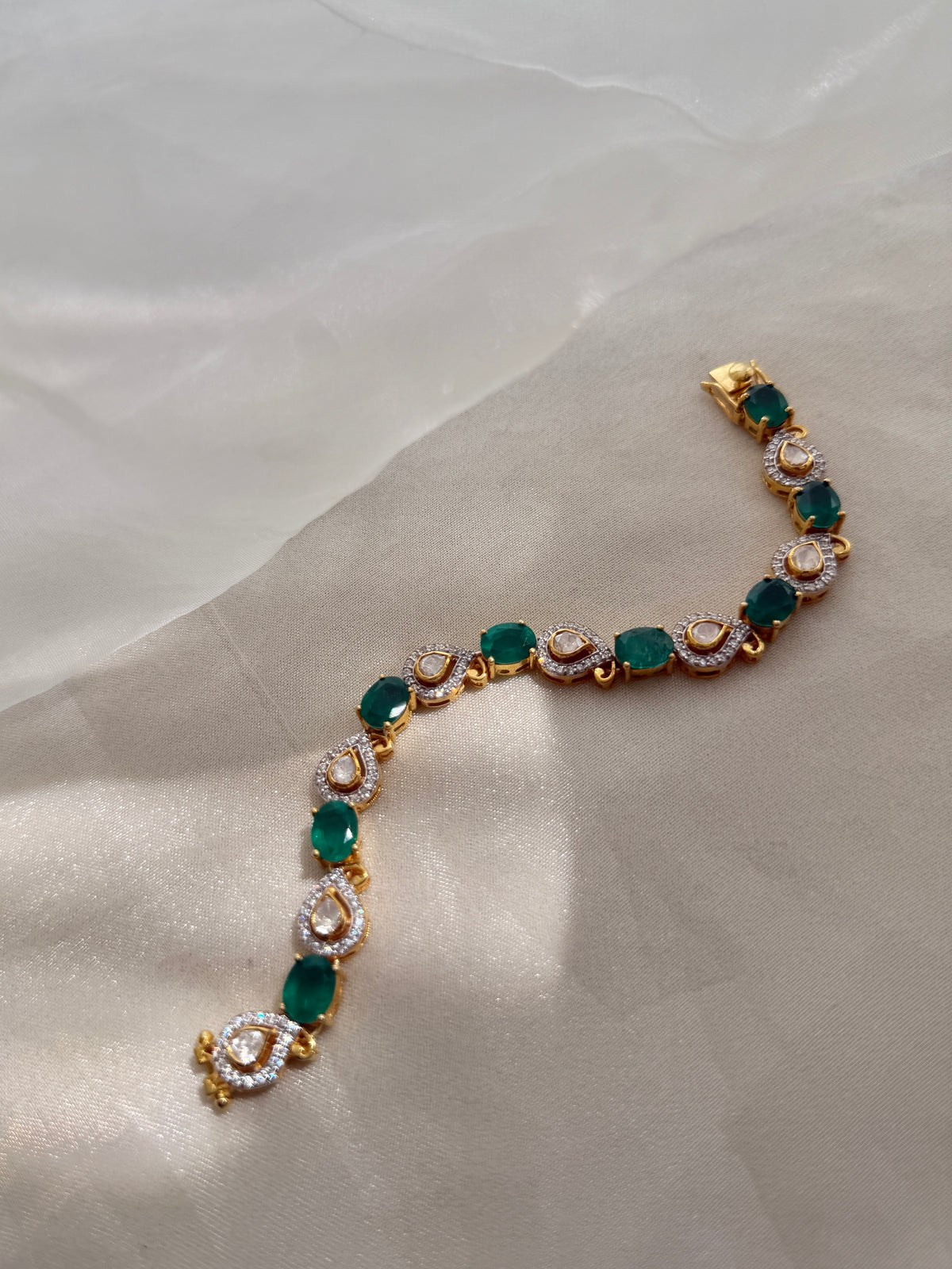 Arzaana Bracelet featuring alternating green oval stones and clear teardrop links in gold-tone settings