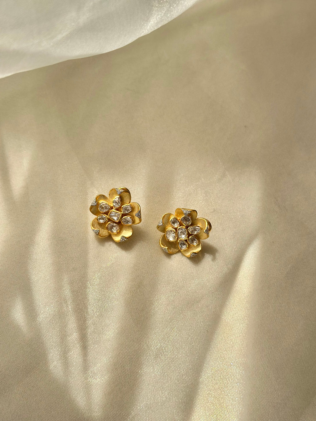 Kusum Polki Earrings featuring sculpted gold-tone flower petals with clustered clear-stone centres.